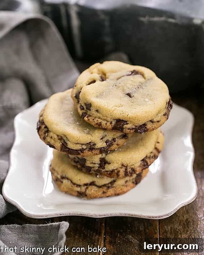 Layered Chocolate Chip Cookies - Dark brown sugar and layers of bittersweet chocolate shards make these a truly unique chocolate chip cookie! Layered Chocolate Chip Cookies stacked on a square white plate, showcasing their thick layers and chocolate shards.