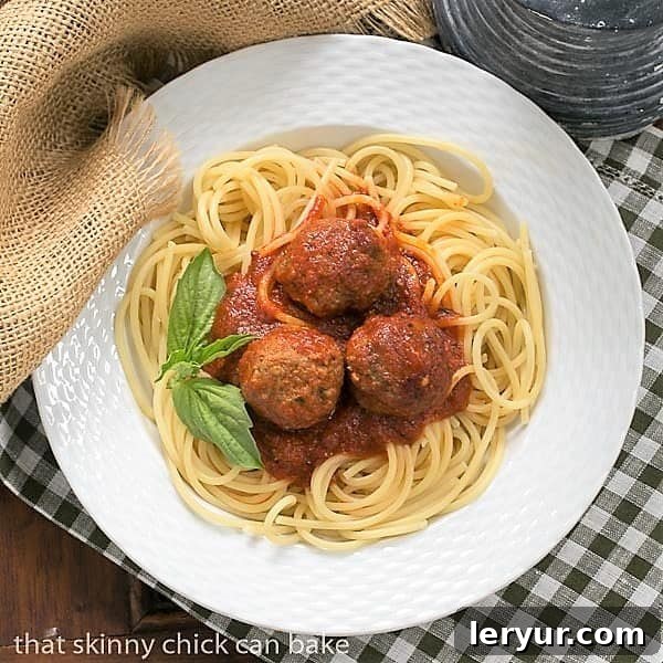 Overhead view of Classic Italian Meat Sauce over pasta and meatballs in a white bowl.