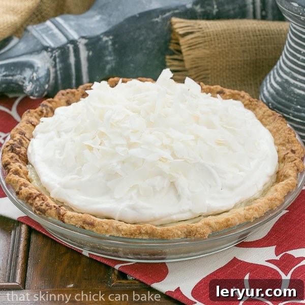 A Whole Coconut Cream Pie Ready to Serve Overhead shot of a full Coconut Cream Pie on a rustic wooden table, with a few slices already served, showcasing its inviting appearance.