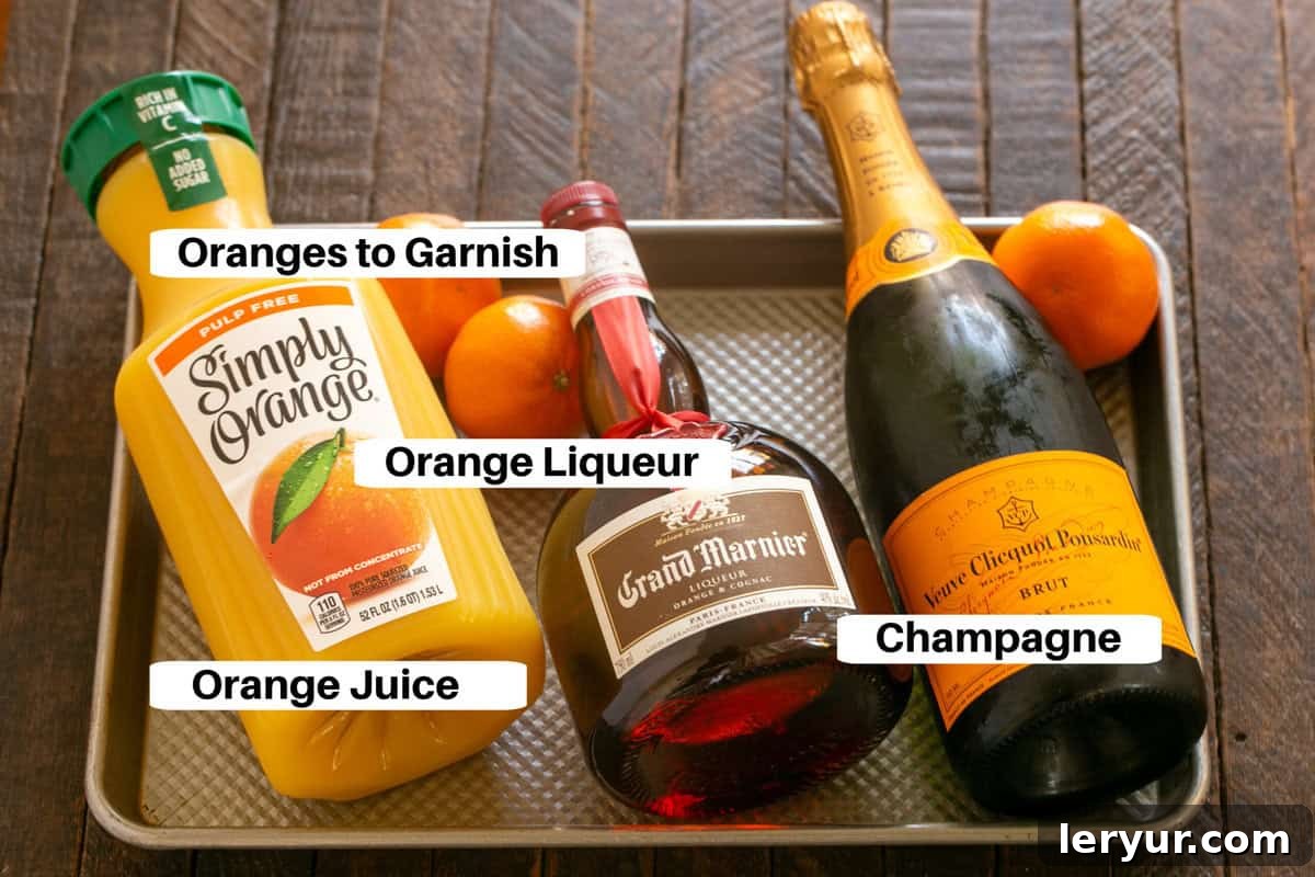 Elevated Grand Marnier Mimosas 2 Grand Mimosa Ingredients with labels, showcasing fresh oranges, sparkling wine, and Grand Marnier.