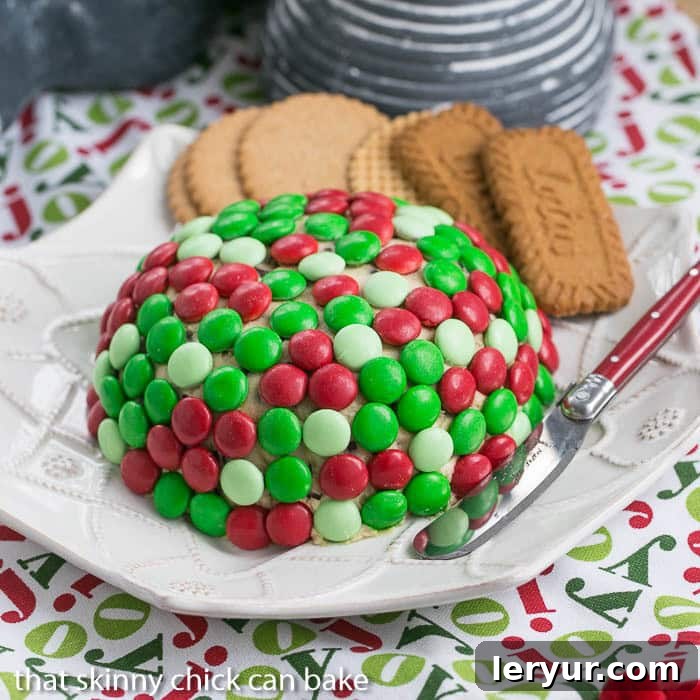 Vibrant Cookie Dough Cheese Ball covered with holiday-themed M&M's, ready for a festive gathering