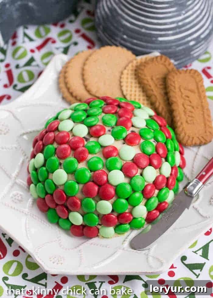 Overhead shot of a Cookie Dough Cheese Ball on a white geometric plate, showcasing its festive topping.