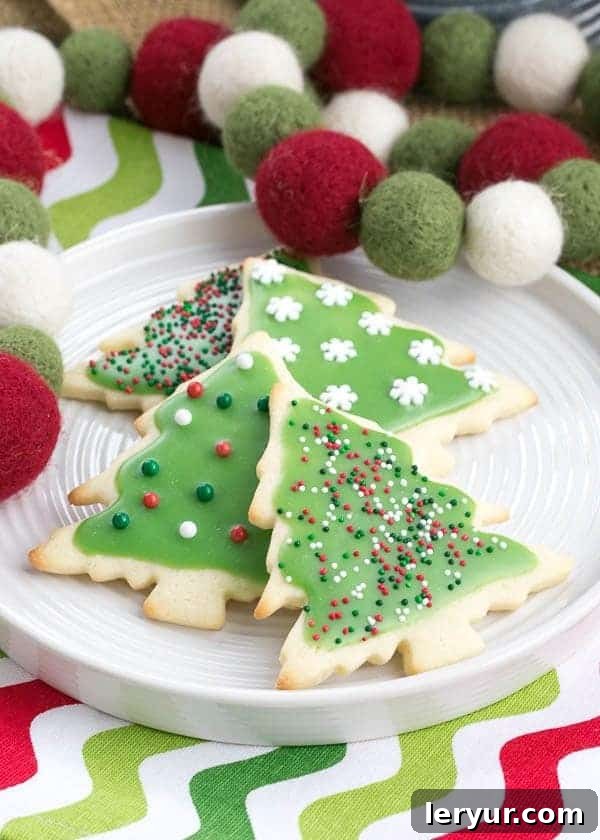 Whimsical Holiday Sugar Cookie Designs 12 A warm and inviting scene featuring the Best Sugar Cookies on a white plate, resting on a charming Christmas napkin, with a festive holiday felt garland draped nearby.