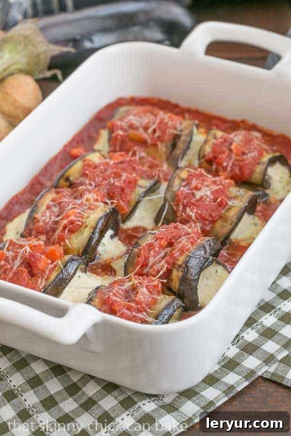 Creamy Ricotta and Mozzarella Stuffed Eggplant Rolls 4 Eggplant Rollatini with Ricotta and Mozzarella arranged neatly in a white casserole dish, ready for baking