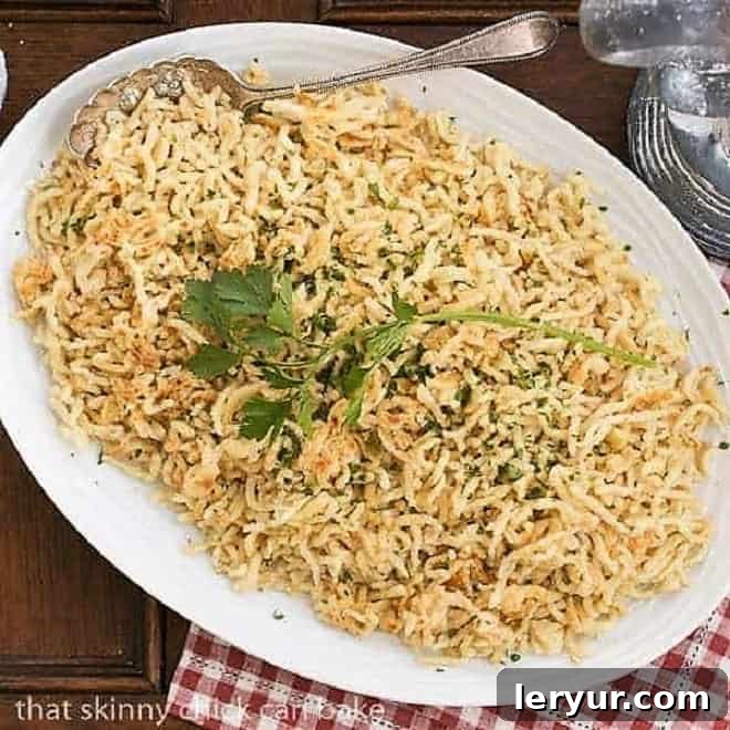 A large serving platter piled high with golden homemade Spaetzle, traditional German egg noodles, ready to be served.