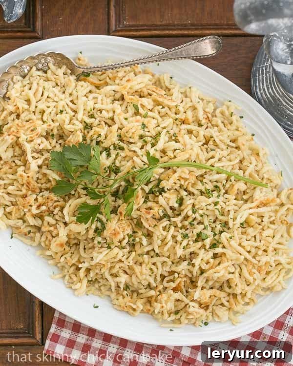 A large platter abundant with freshly made, golden homemade Spaetzle, elegantly garnished with fresh herbs, signifying its readiness for serving.