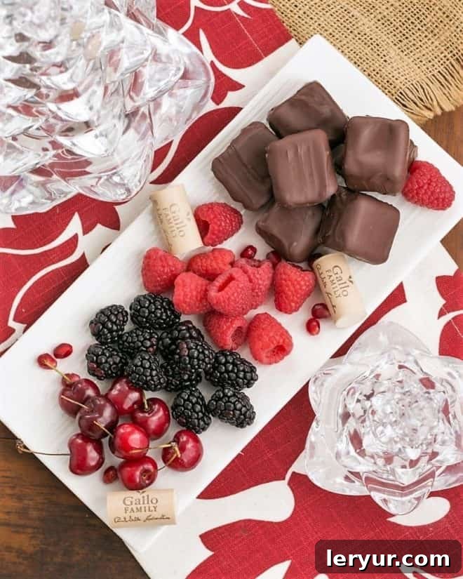Chocolate Dipped Cheesecake Bites - Exquisite, bite-sized gems for your holiday buffet! An inviting overhead shot of Chocolate Dipped Cheesecake Bites artfully arranged with various fresh fruits, highlighting their vibrant colors and delectable texture.