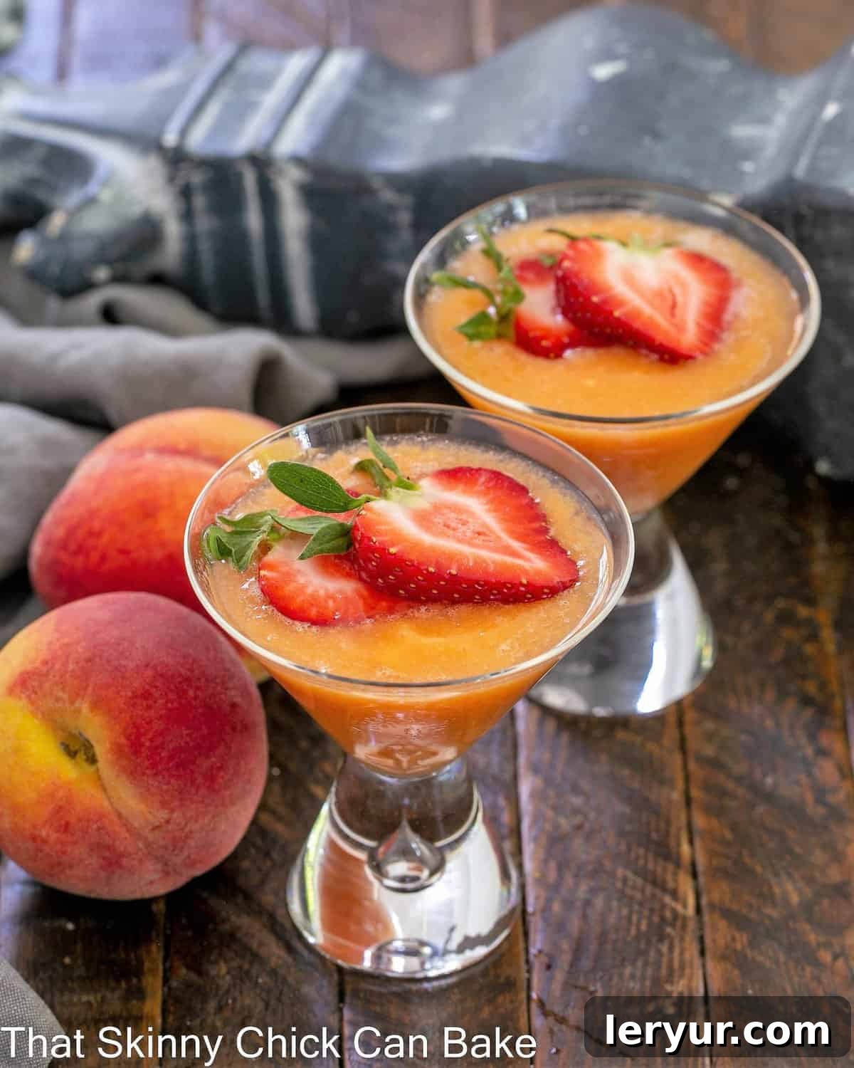 Two peach bellinis garnished with strawberry slices, ready to be enjoyed.