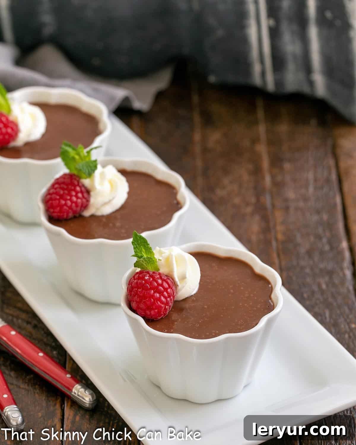 Irish Cream Pots de Creme - Rich and silky pots de creme flavored with Irish cream Pots de creme on a white ceramic tray with red handled spoons.