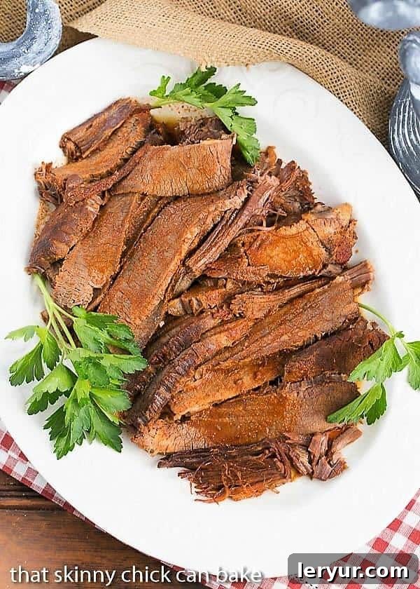 Texas brisket is typically a cut of beef that is smoked for a long time at a long temperature. When that's not possible, make this easy oven braised Texas brisket recipe for big, bold flavor in a juicy oven cooked beef brisket! white serving platter filled with slices of Oven Braised Texas Brisket
