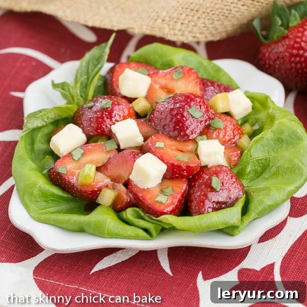 Close-up of Basil, Brie, and Strawberry Salad showing creamy brie cubes nestled among fresh strawberry slices and vibrant green basil.