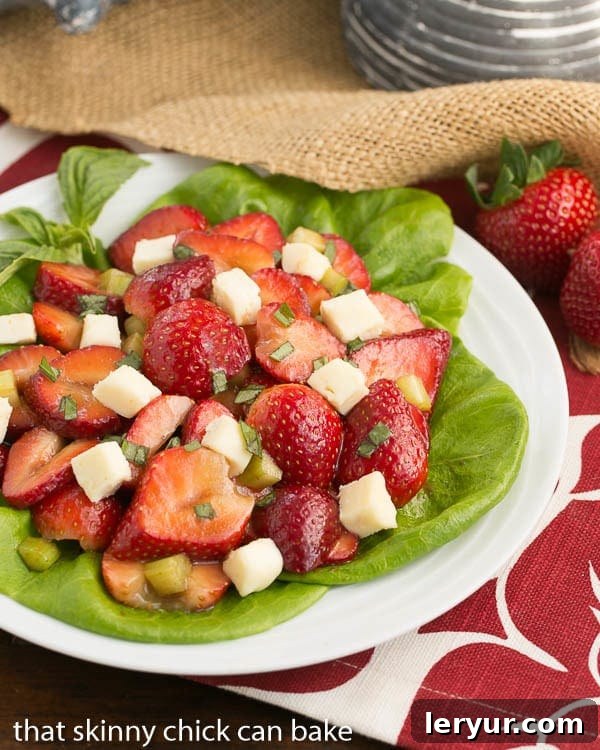 A beautifully presented Basil, Brie, and Strawberry Salad on a white plate, showcasing its vibrant colors and fresh ingredients.