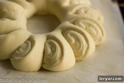 Tea roll dough filled, rolled and risen on a parchment lined pan, pre-baking