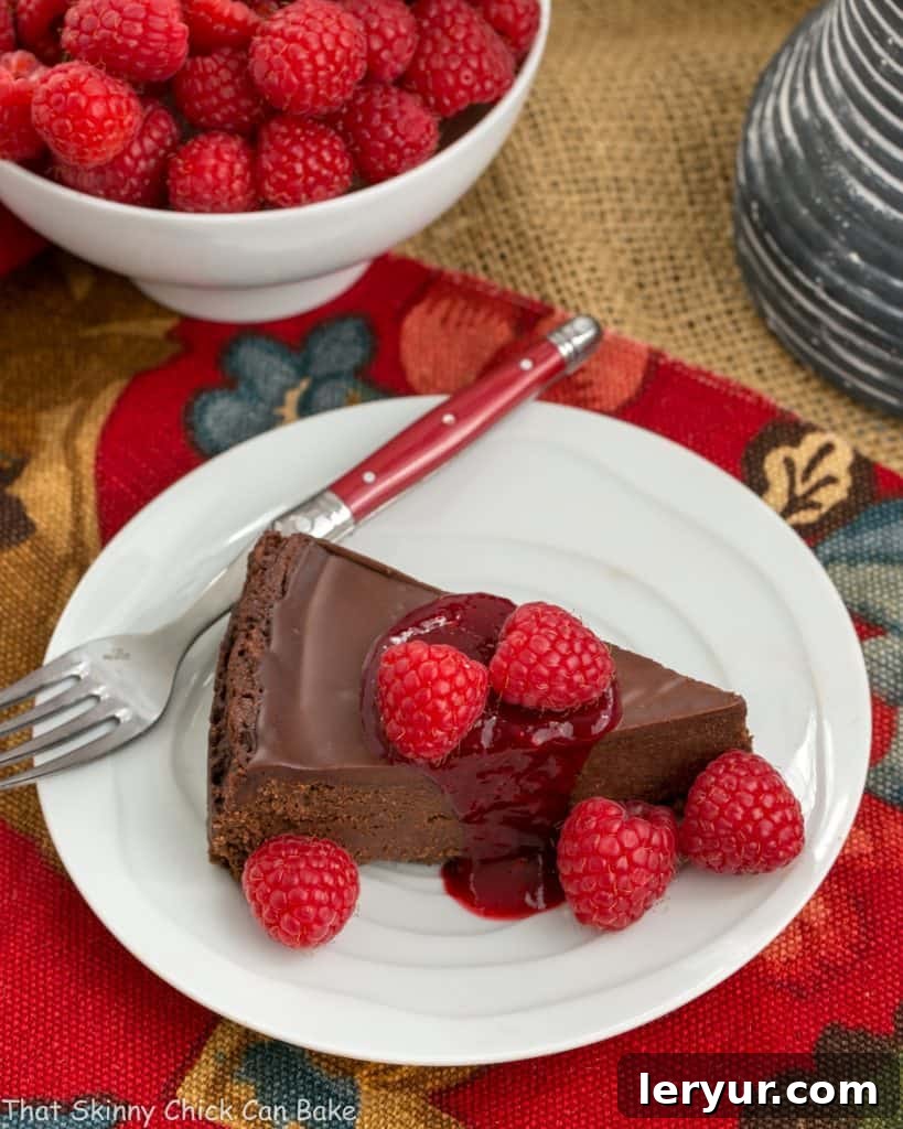 Decadent Chocolate Torte with Raspberry Coulis 2 Overhead shot of a gluten-free Chocolate Torte on a white plate, beautifully garnished with a lustrous chocolate ganache and fresh, juicy raspberries, ready to be served.