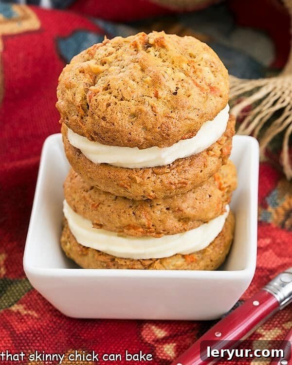 Carrot Cake Whoopie Pies - All the magnificent flavors of a moist carrot cake recipe in these fabulous whoopie pies. 2 Carrot Cake Whoopie Pies stacked in a white bowl.