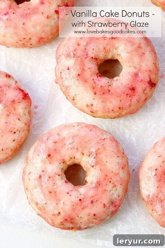 Tender and fluffy vanilla cake donuts topped with a luscious, sweet strawberry glaze, making a perfect spring breakfast or dessert treat.