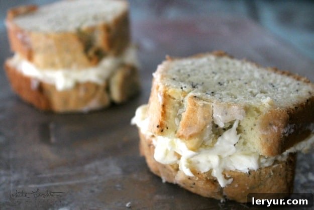 A dense and flavorful almond poppy seed pound cake, perfectly paired with a bright and tangy lemon cream cheese frosting for an exquisite dessert.
