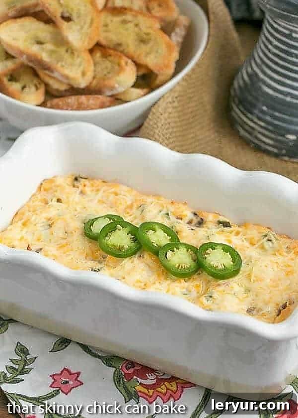 Creamy and Cheesy Jalapeno Popper Dip in a white ceramic loaf pan, garnished with fresh cilantro and a sprinkle of spices, ready to be served as a delightful appetizer.