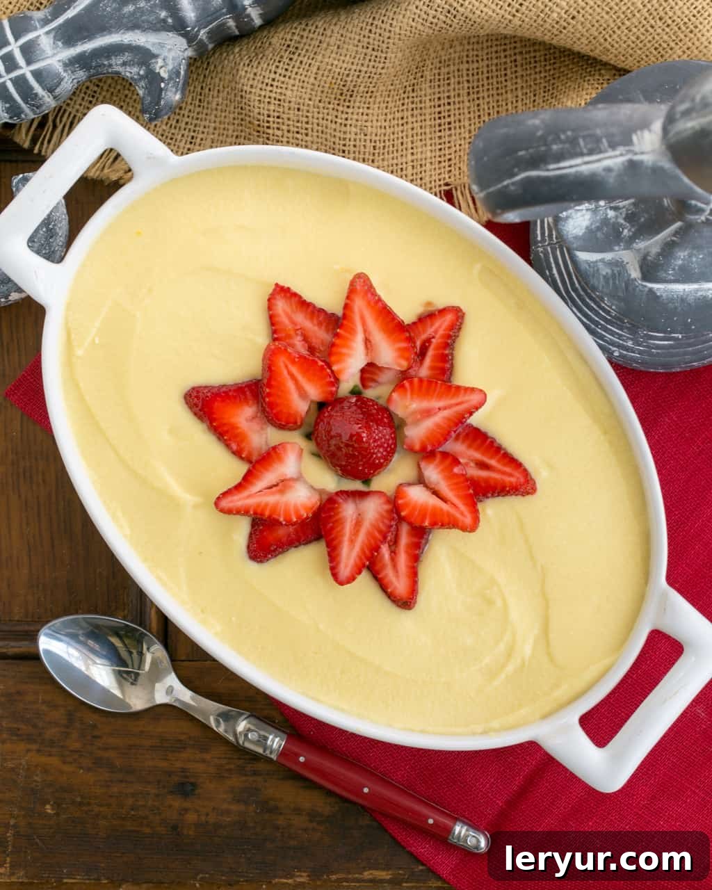 Berry Tiramisu with Grand Marnier - A strawberry twist on the Italian classic with mascarpone and Grand Marnier soaked ladyfingers! Berry Tiramisu with Grand Marnier in an oval casserole dish, garnished with abundant fresh strawberry slices and mint.