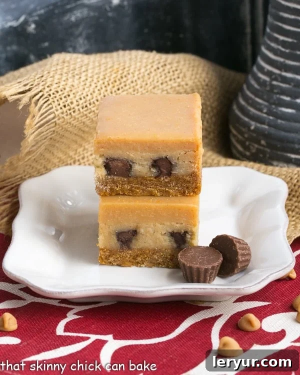 Close-up of Peanut Butter Cheesecake Bars stacked on a square white dessert plate, showing the creamy filling and ganache.