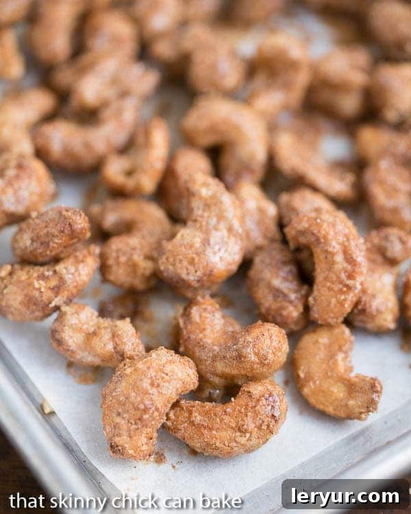 Spicy Sugared Cashews cooling on a parchment-lined baking sheet.