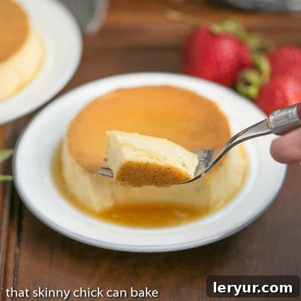Mini Vanilla Flans - The classic Spanish custard and caramel dessert in individual servings! Close-up of a forkful of mini vanilla flan with a whole mini flan on a white plate in the background.