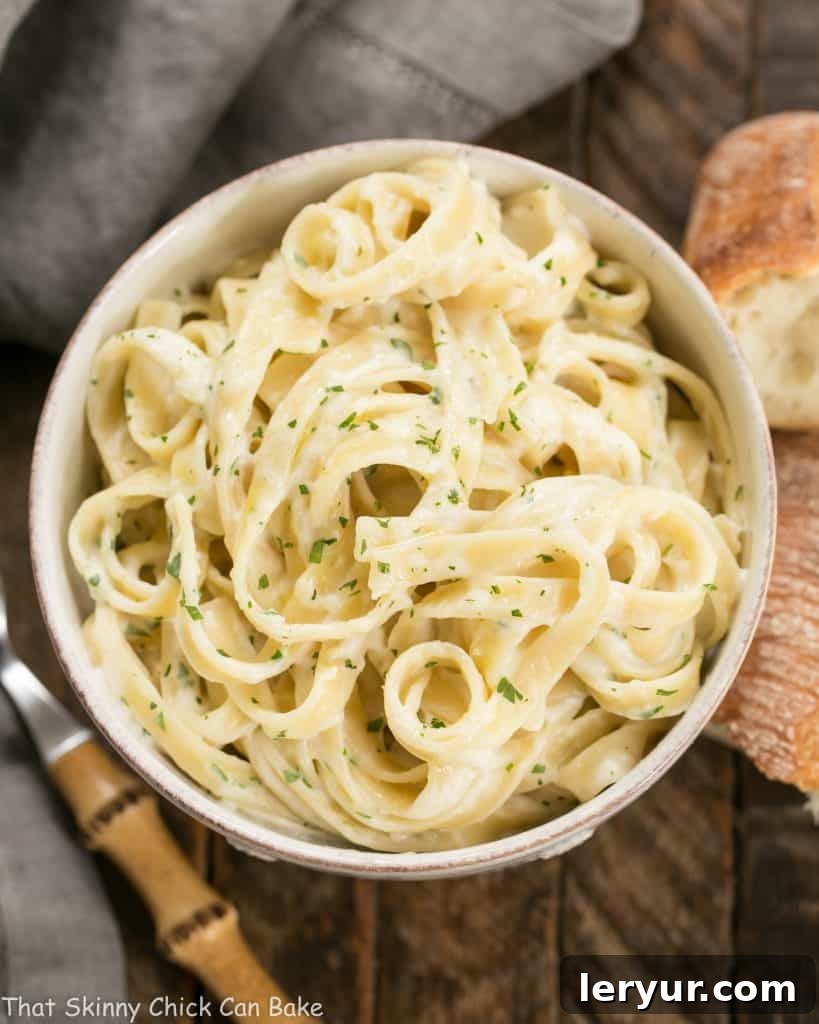 Light Fettuccine Alfredo - A creamy flavorful, lightened up Fettuccine Alfredo that tastes amazing! Overhead view of a bowl Light Fettuccine Alfredo.