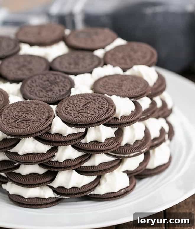 Decadent Oreo Icebox Cake with layers of chocolate wafers and sweetened whipped cream, garnished with more Oreos.