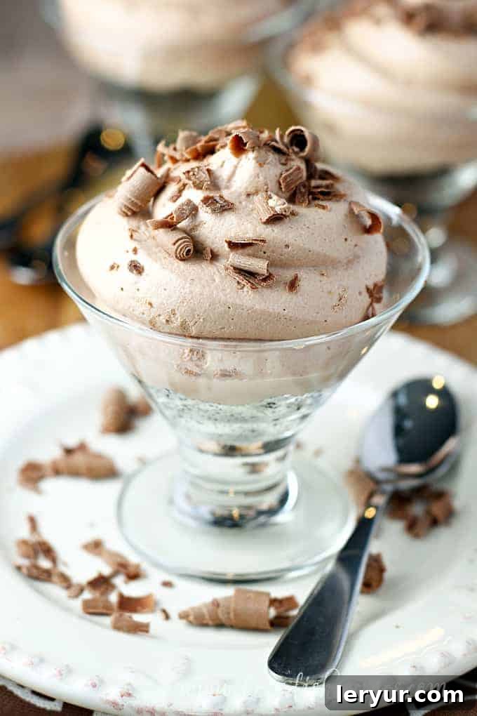 Smooth and rich No-Bake Nutella Cheesecake, topped with a generous layer of Nutella and chocolate shavings.