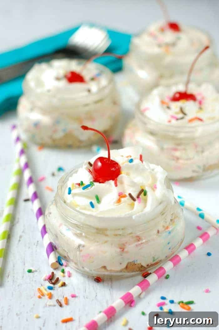 Colorful No Bake Funfetti Cheesecake Cups, served in individual jars with sprinkles on top.