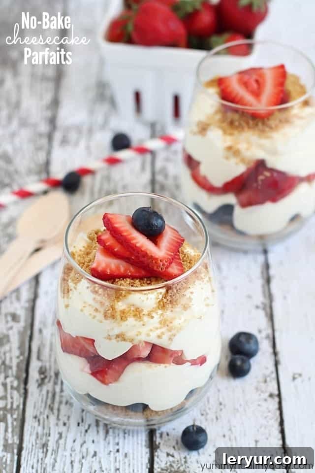 Elegant No-Bake Cheesecake Parfaits layered in tall glasses, showcasing creamy cheesecake and fruit.