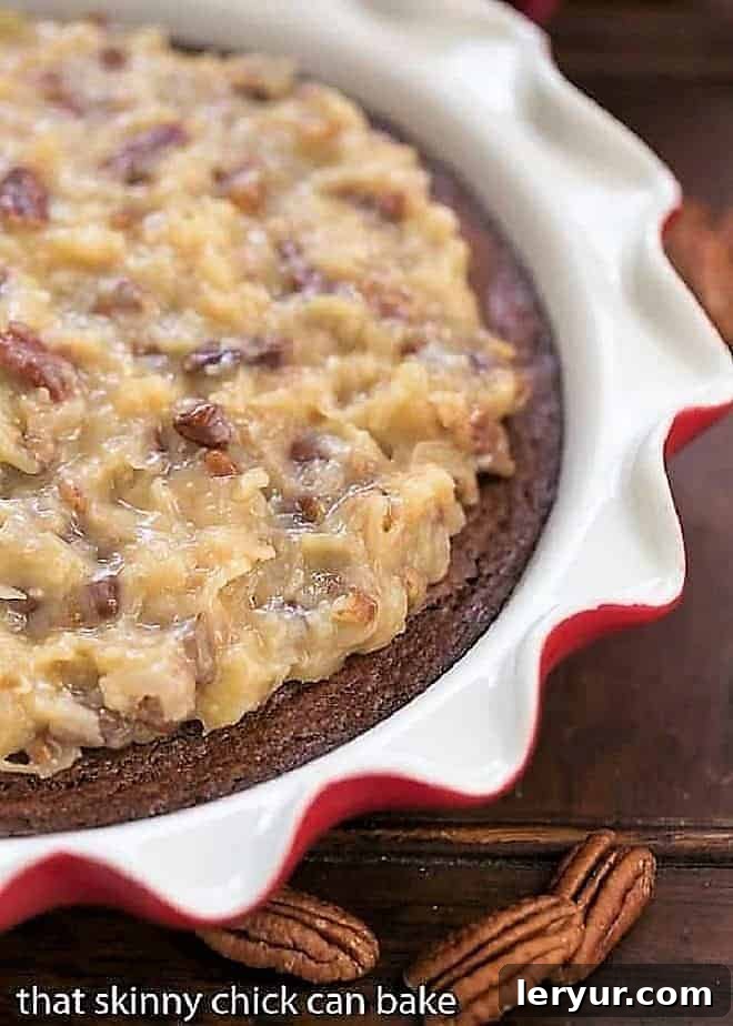 German Chocolate Brownie Pie: A decadent fudgy brownie topped with the classic coconut and pecan German chocolate frosting! German Chocolate Brownie Pie in a ruffle edged pie plate with pecan halves