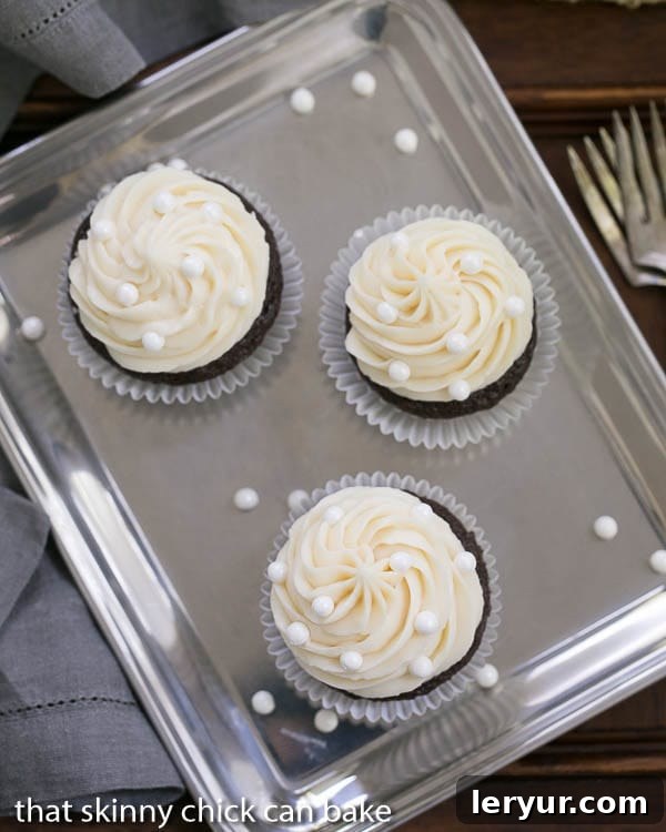 Vanilla Buttercream Topped Cocoa Cupcakes - Moist, scrumptious chocolate cupcakes topped with a mound of vanilla buttercream Overhead view of Vanilla Buttercream Topped Cocoa Cupcakes on a silver tray, highlighting the perfect frosting swirls