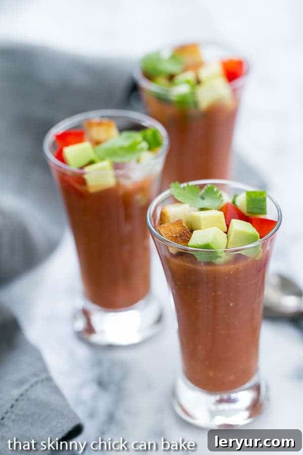 Gazpacho Shooters - Appetizer size portions of the classic Spanish gazpacho soup Vibrant red Gazpacho Shooters elegantly arranged on a sleek marble tray, ready for serving at a summer party.