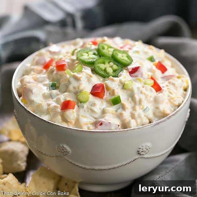 Sour Cream Corn Dip, a creamy and vibrant dip garnished with fresh herbs, served with tortilla chips.