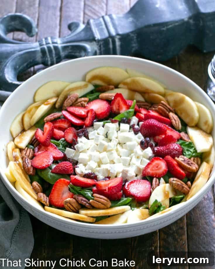 Strawberry Spinach Salad with Feta, topped with pecans, apples, and dried cranberries.