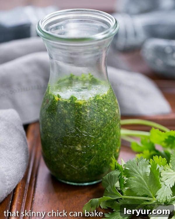 Vibrant green Chimichurri Sauce stored in a clear glass jar, showcasing its fresh texture.