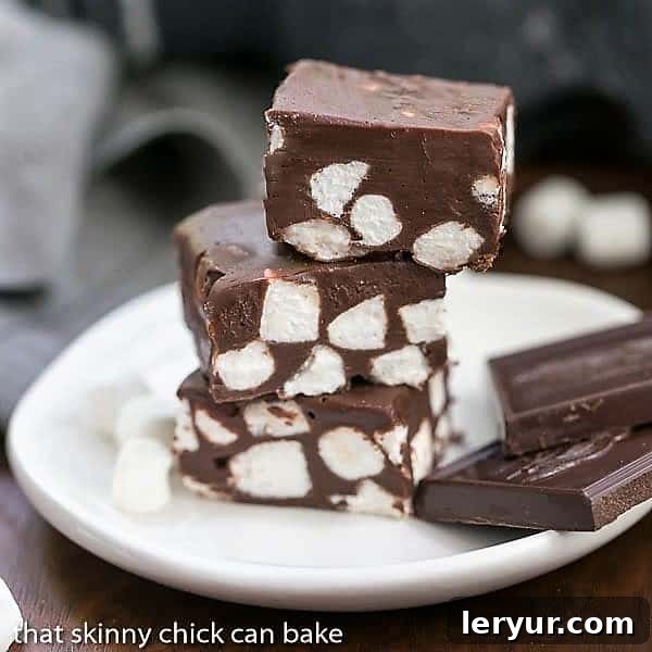 Perfectly cut Chocolate Marshmallow Fudge squares – A simple recipe for a delightful treat! A stack of delicious Chocolate Marshmallow Fudge squares on a small white plate, perfectly cut and ready to be served.