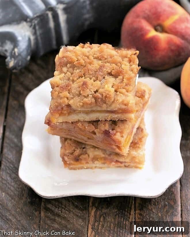 3 peach pie bars stacked on a square white plate