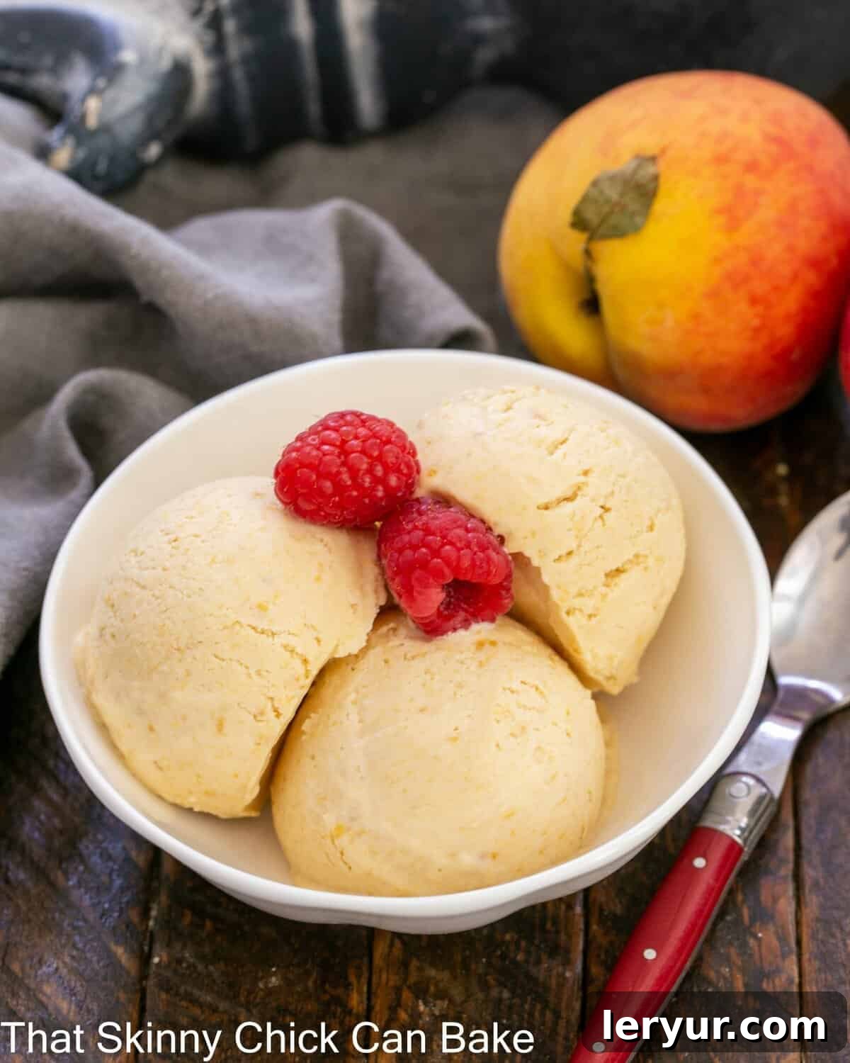 Roasted Peach Ice Cream (No-Churn) 2 No- Churn Peach ice cream in a shallow bowl with raspberry garnish.