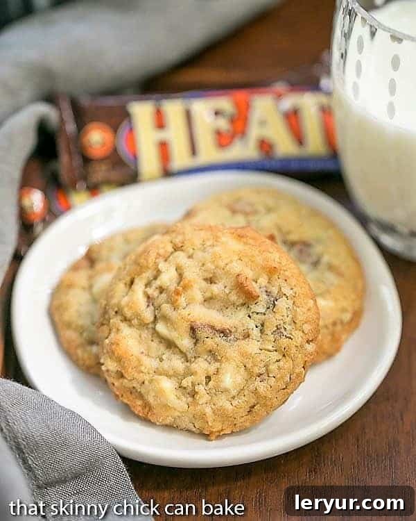 White Chocolate Toffee Chunk Cookies - oatmeal cookies chock full of deliciousness! White Chocolate Toffee Chunk Cookies on a white ceramic plate with a glass of milk