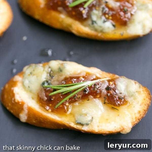 Fig Gruyere Crostini - An unusual combination of toppings that's sure to be a hit! Fig Gruyere Crostini garnished with rosemary on a slate platter.