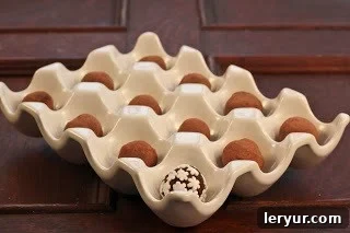 Several homemade chocolate truffles, dusted with cocoa powder, nestled in a charming ceramic egg crate