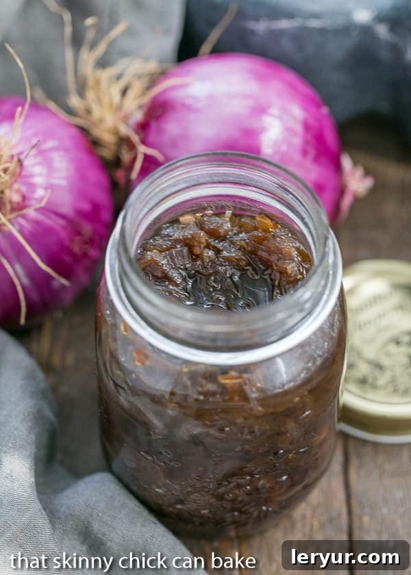 Red Onion Confit - A French-inspired condiment, perfect for elevating your culinary experience! Homemade Red Onion Confit cooling in a glass canning jar, showcasing its beautiful color and texture.
