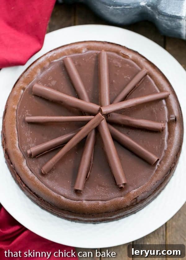 Chocolate Trilogy Cheesecake 2 An inviting overhead view of a magnificent Triple Chocolate Cheesecake, beautifully arranged on a white serving plate, highlighting its smooth, glossy ganache topping and the promise of rich flavor within.