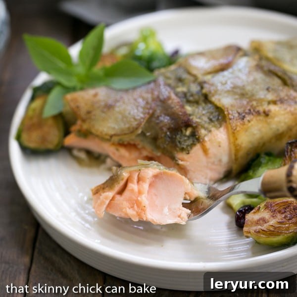 Potato Shingled Salmon on a white plate with a forkful of salmon in focus