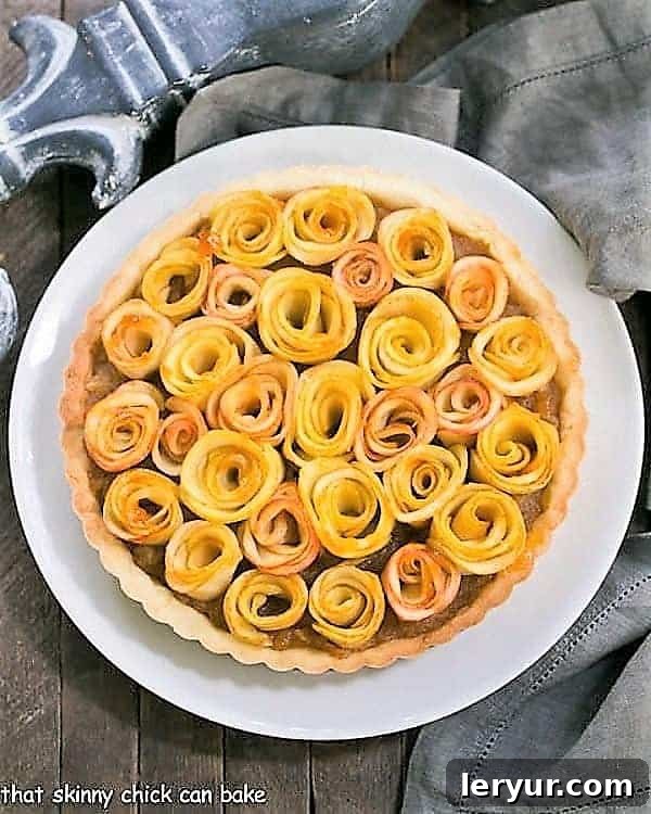 Overhead view of a stunning Rose Apple Tart on a white ceramic plate, showcasing the meticulous arrangement of apple roses.