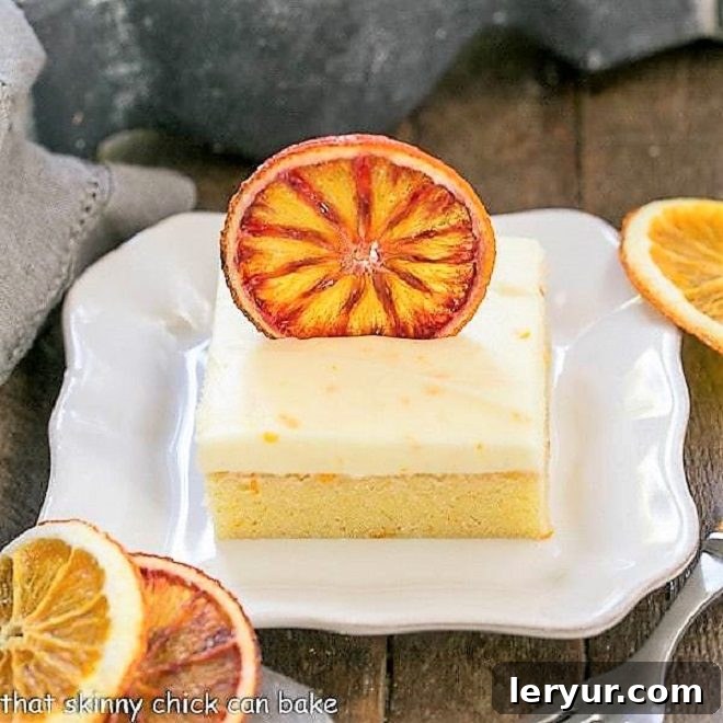Zesty Orange Cake with Cream Cheese Frosting 3 Orange Cake with Cream Cheese Frosting on a square white plate with dried orange slices