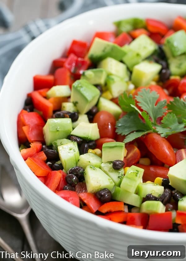 Fiesta Salad - A veggie packed Tex-Mex Salad with a honey lime dressing Close view of Fiesta Salad garnished with a sprig of cilantro