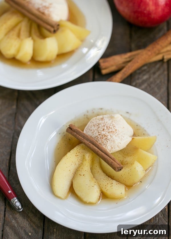 Tea Poached Apples - Tea, honey and wine poached apples with a dollop of Calvados spiked mascarpone cream Tea Poached Apples on white plates, elegantly garnished with Calvados mascarpone cream and cinnamon sticks